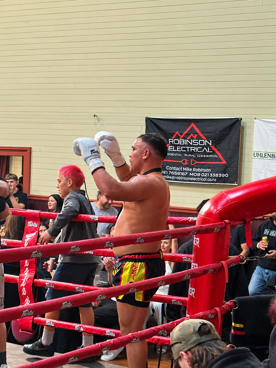 Boxer in the ring with a Robinson Electrical sponsor banner behind him