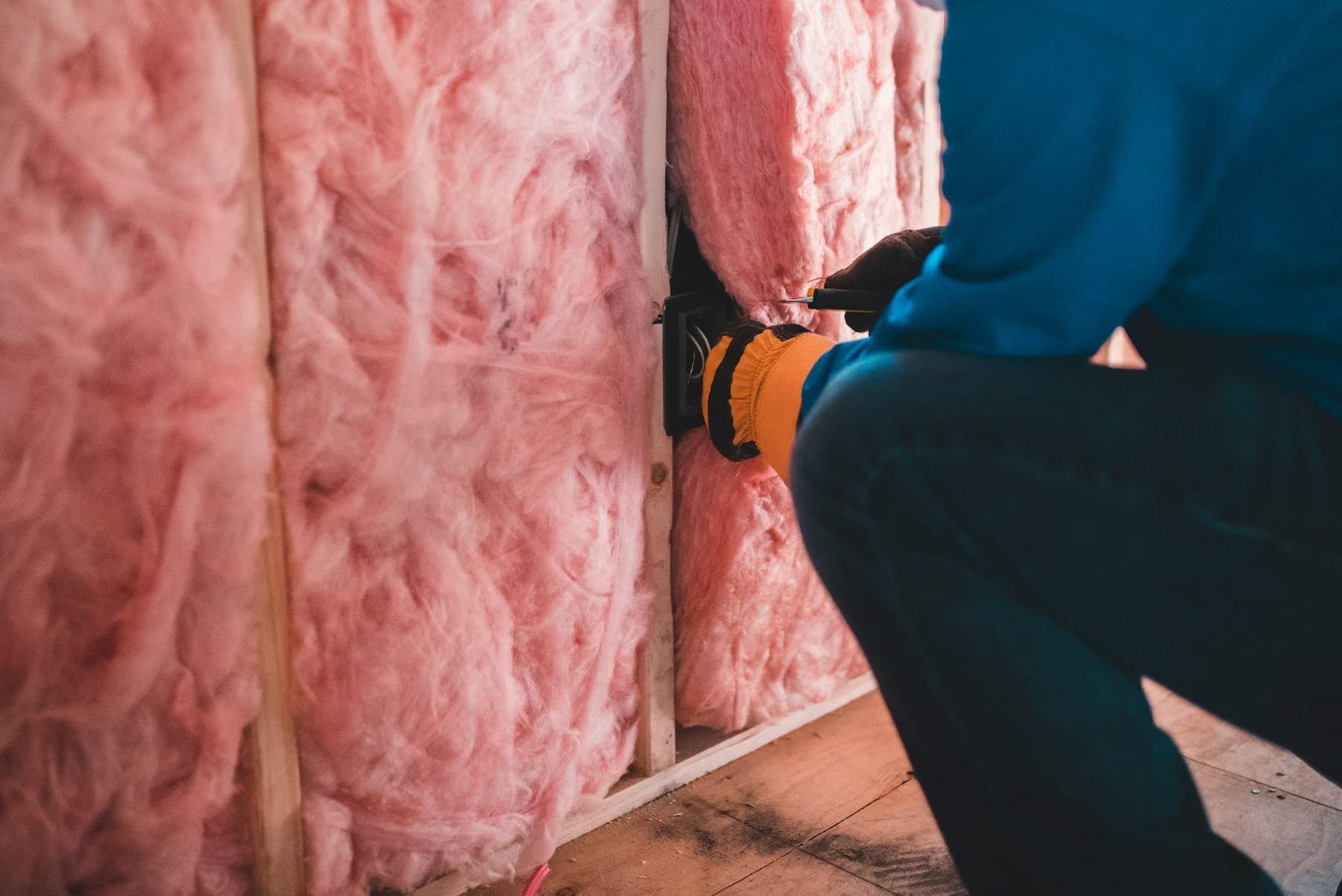 Electrician wiring a wall outlet box during a renovation
