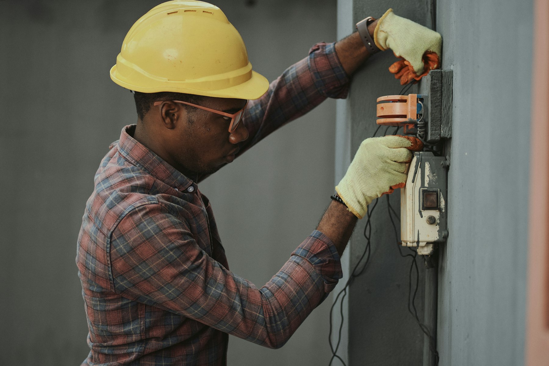Electrician working on wall-mounted switchgear