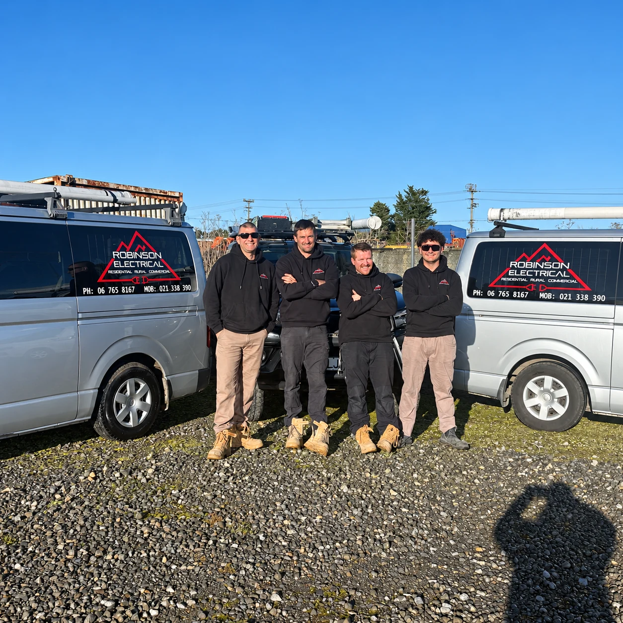The Robinson Electrical crew beside their branded work vans
